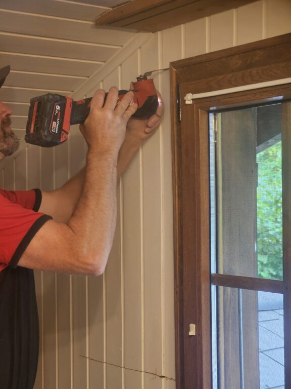 a man using a drill to drill a window