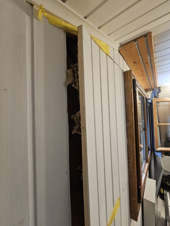 a white wall with a piece of wood